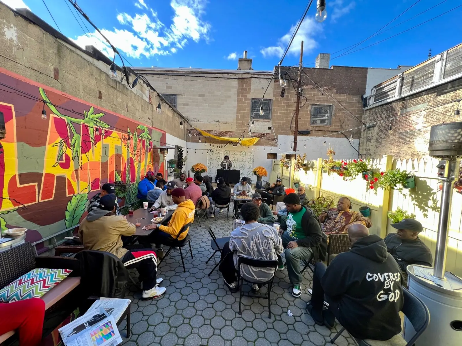 Community members gathered around tables in an outdoor courtyard